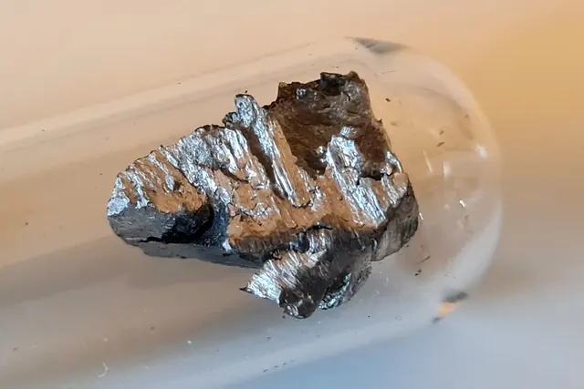 Neodyymimetallinpala lasiampullissa argonsuojakaasussa